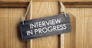 Dark Interview In Progress Sign Hanging from Light Wood Door - Interview Q&A Don’ts