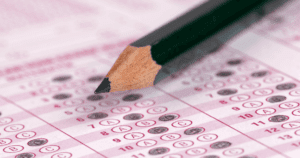 Pink Scantron in Deep Focus with Answers Filled in and Black Pencil in Foreground