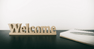 Welcome Decoration Sitting on Black Desk with Blank Notebook Sitting Beside Welcoming New Employee
